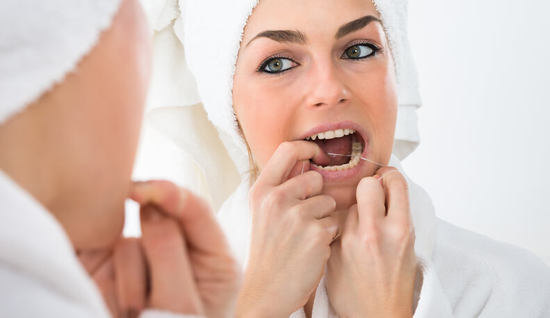 Woman Flossing Teeth