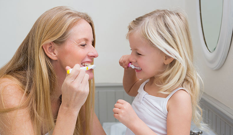 mom daughter brushing teeth